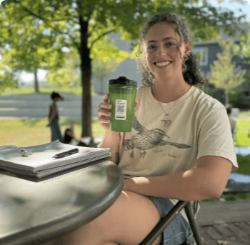 Women holding a green waterbottle that has a sticker with QR